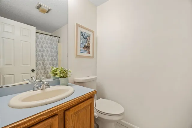 a bathroom with a granite countertop sink toilet and a mirror