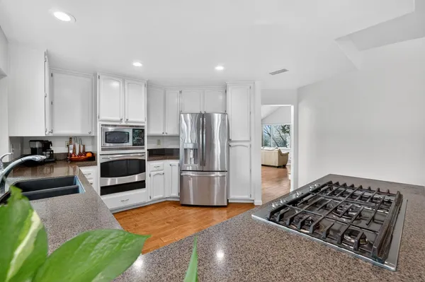 a kitchen with stainless steel appliances granite countertop a stove a refrigerator and a sink