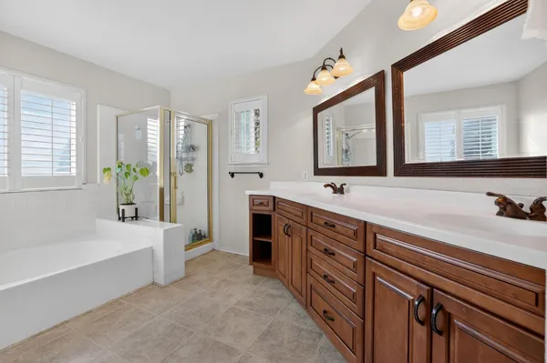 a spacious bathroom with a tub double sink and a mirror