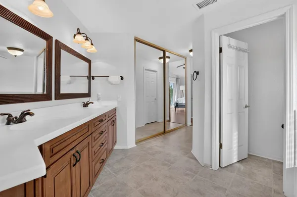 a bathroom with a double vanity sink mirror and shower