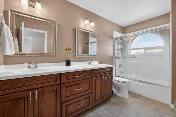 a bathroom with a toilet a sink a mirror and a shower