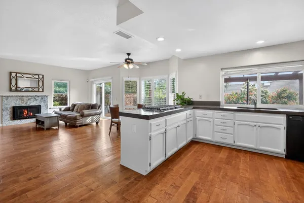 a kitchen with stainless steel appliances granite countertop wooden floors and white cabinets