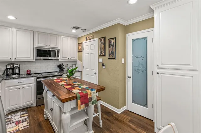 a kitchen with stainless steel appliances granite countertop a stove refrigerator sink and microwave