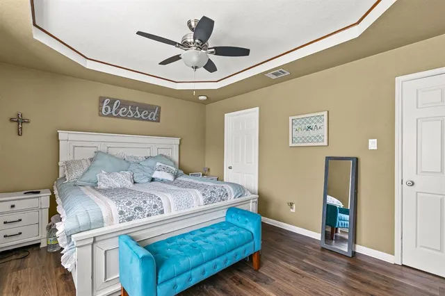 a bedroom with a large bed and a ceiling fan
