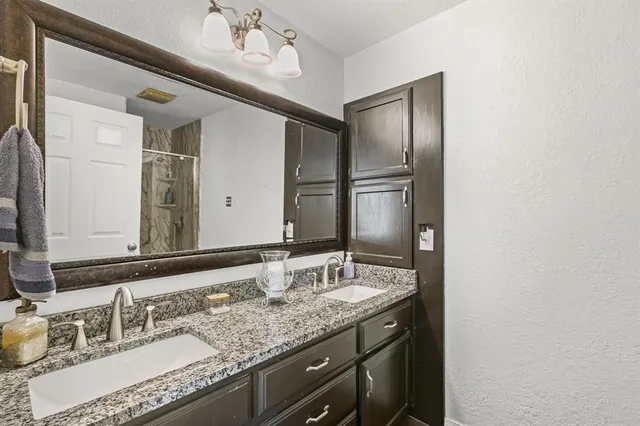 a bathroom with a granite countertop sink and a mirror