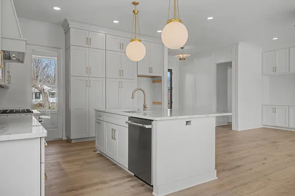 a kitchen with stainless steel appliances granite countertop a sink a oven and a kitchen island