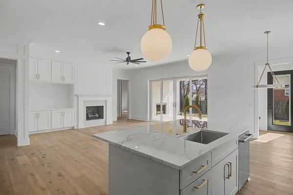 a kitchen with granite countertop a stove and white cabinets