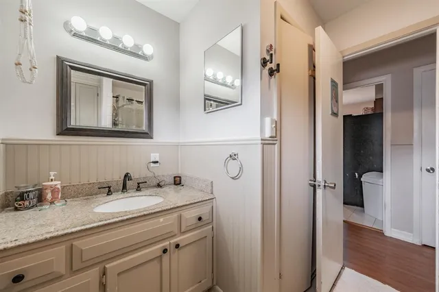 a bathroom with a granite countertop sink vanity mirror and shower