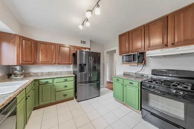 a kitchen with cabinets a refrigerator and a stove top oven