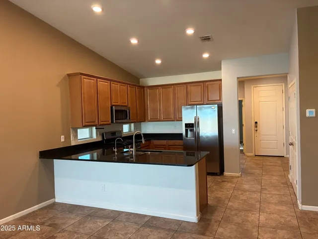 a kitchen with kitchen island granite countertop a cabinets and refrigerator