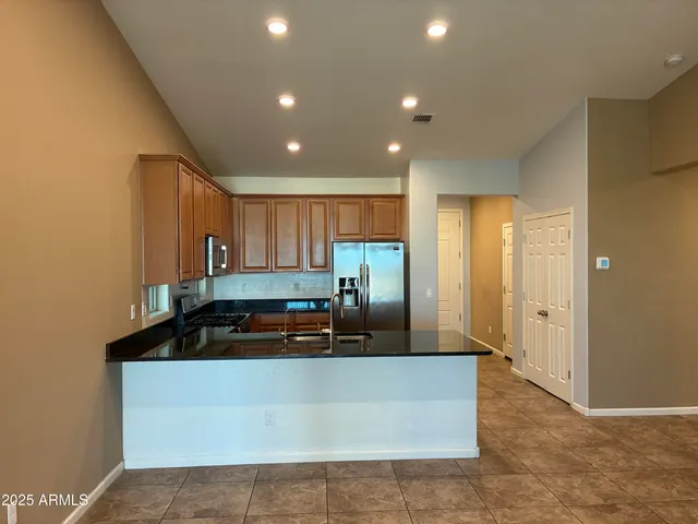 a kitchen with granite countertop a sink and a refrigerator