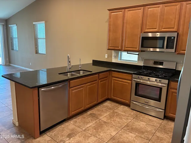 a kitchen with granite countertop a sink and steel appliances