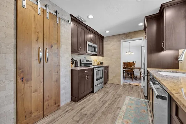 a kitchen with stainless steel appliances granite countertop a refrigerator and a stove top oven
