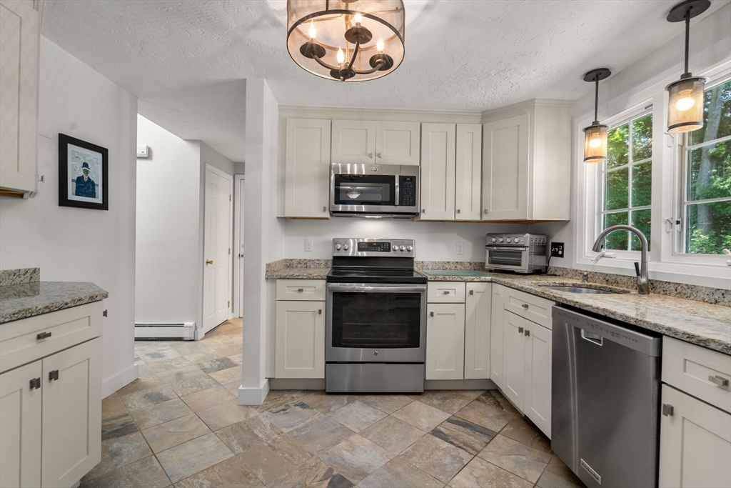 15 Mockingbird Lane Maynard, MA 01754 - Photo 8 of 31 a kitchen with stainless steel appliances granite countertop a stove sink and microwave