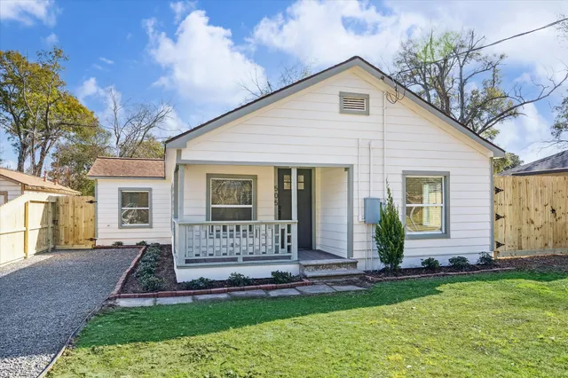 a front view of a house with a garden and yard