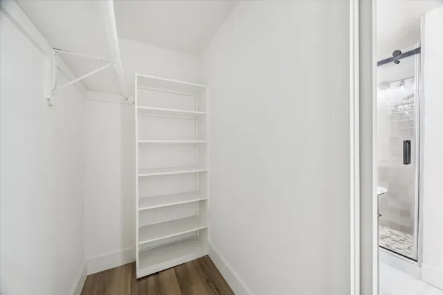 a view of a walk in closet with wooden floor