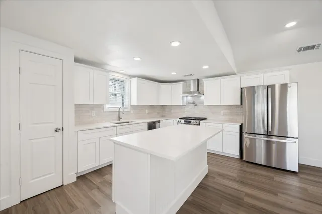 a kitchen with white cabinets and stainless steel appliances