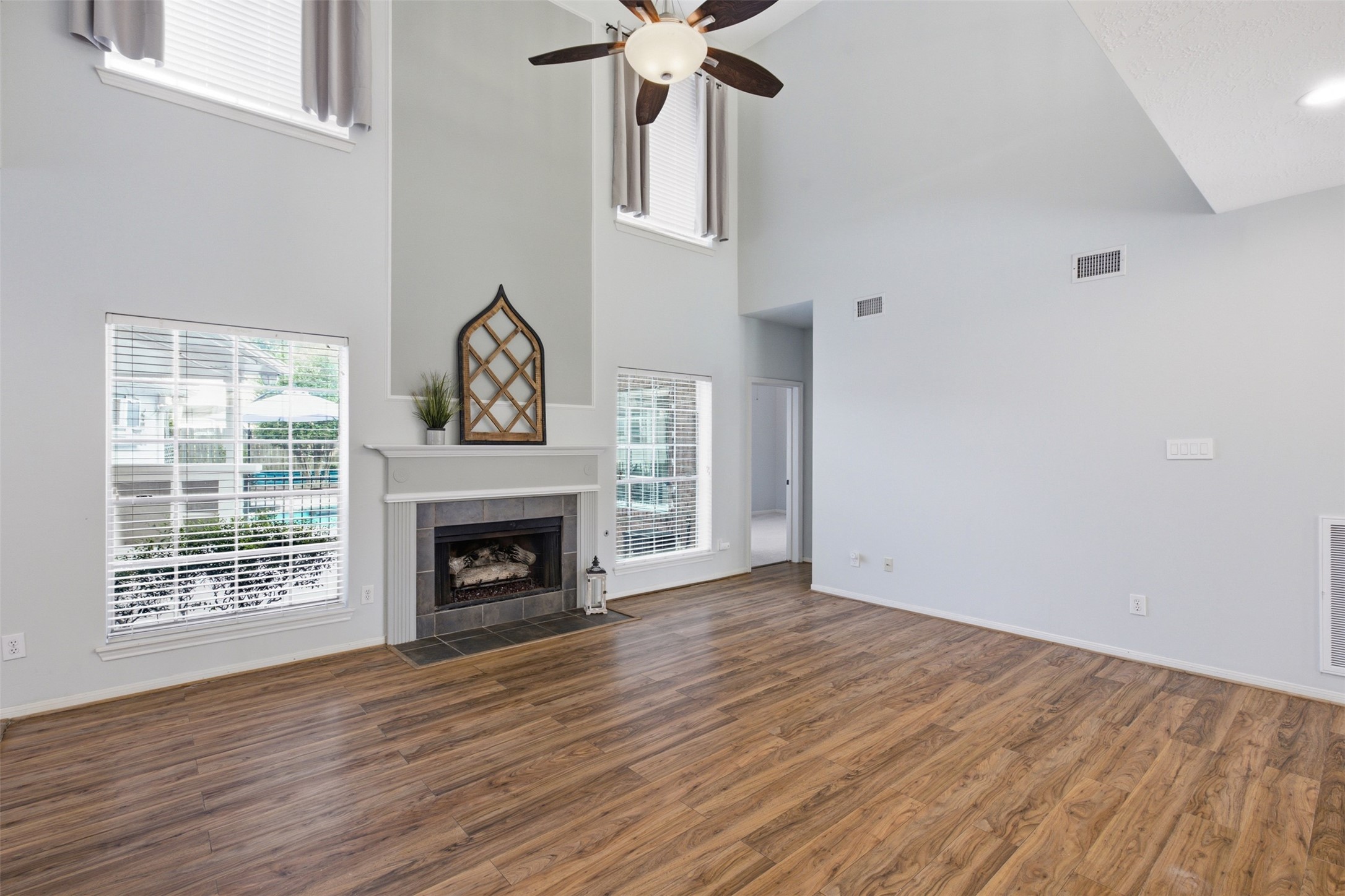 323 Magic Oaks Court Spring, TX 77388 - Photo 15 of 49 Without the virtual staging, the living room remains a showstopper. A gas log fireplace is the focal point with a lovely view of the pool area on either side making this room the perfect place to relax in every season.