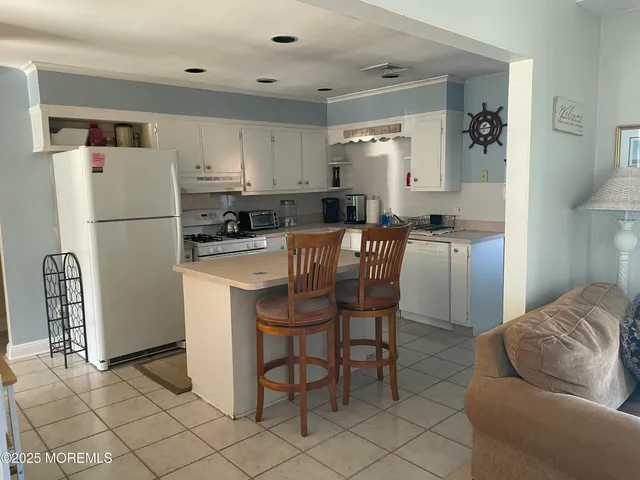 a kitchen with stainless steel appliances a refrigerator a stove a dining table and chairs