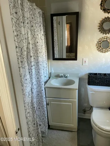 a bathroom with a toilet sink and mirror