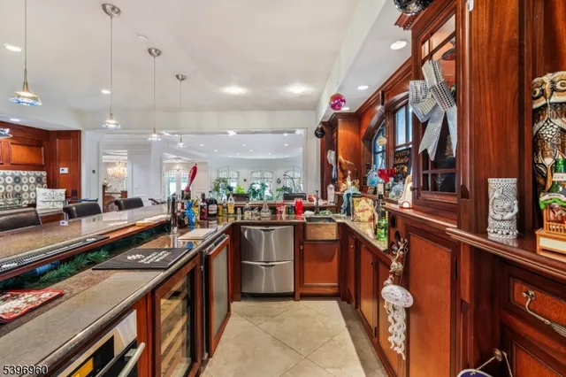a dining hall with stainless steel appliances a dining table and chairs with the floor to ceiling window