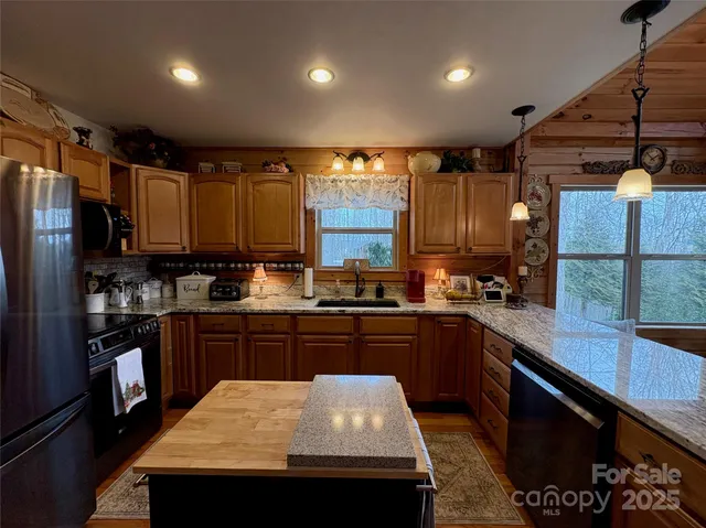 a kitchen with kitchen island a sink stove and refrigerator