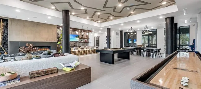 a large living room with stainless steel appliances kitchen island granite countertop furniture and a large window