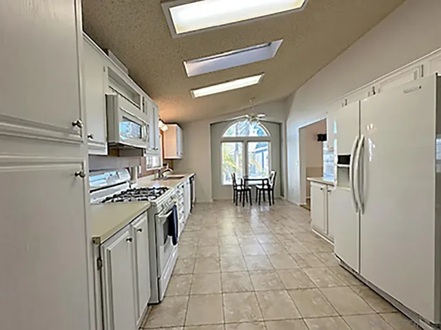 a kitchen with stainless steel appliances granite countertop a refrigerator a stove and a sink