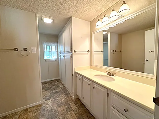 a spacious bathroom with a tub sink and mirror