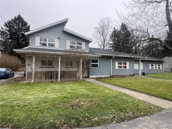 a view of a house with a yard and sitting area