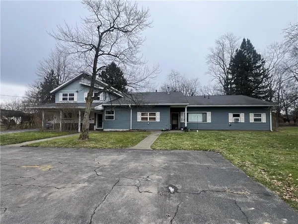 a view of a big house with a big yard and large tree