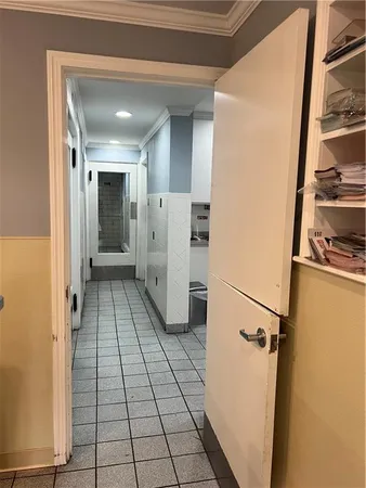 a view of a refrigerator in kitchen and an empty room