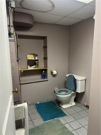 a bathroom with a toilet and a mirror