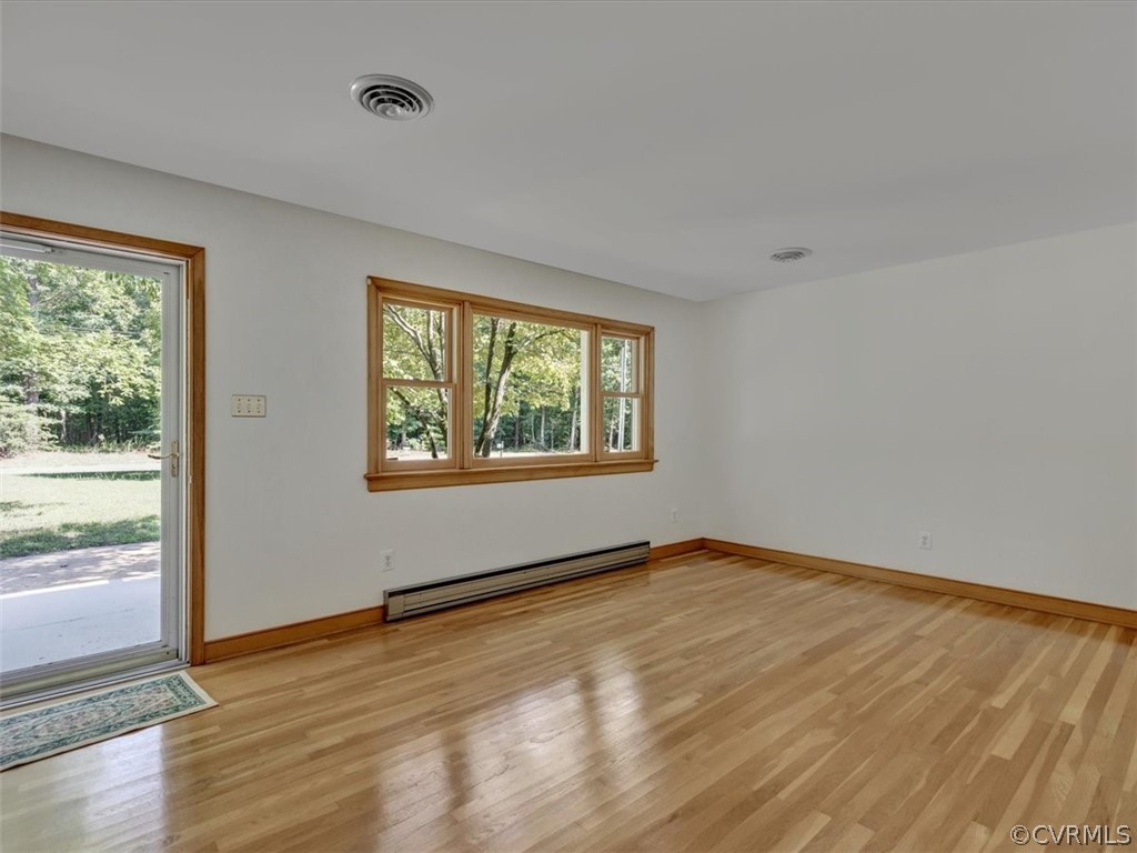 8801 Belmont Road Chesterfield, VA 23832 - Photo 3 of 24 a view of an empty room with wooden floor and a window