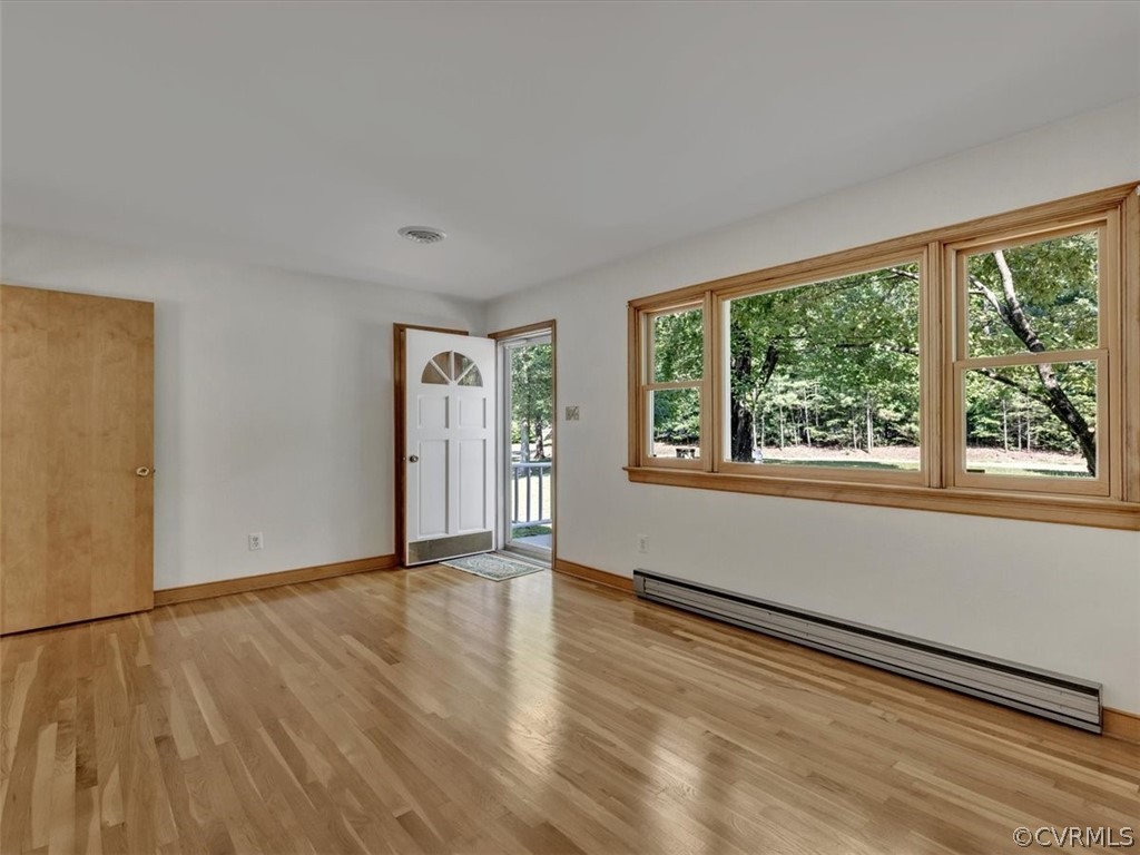 8801 Belmont Road Chesterfield, VA 23832 - Photo 4 of 24 a view of an empty room with wooden floor and a window