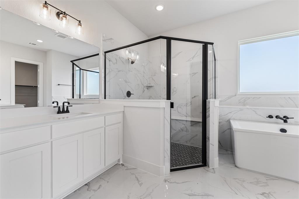 12108 Crystal Drive Krum, TX 76249 - Photo 34 of 40 a bathroom with a double vanity sink a mirror and a bathtub