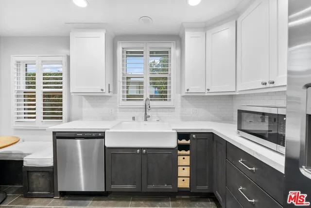 a kitchen with stainless steel appliances granite countertop a sink a stove and a microwave
