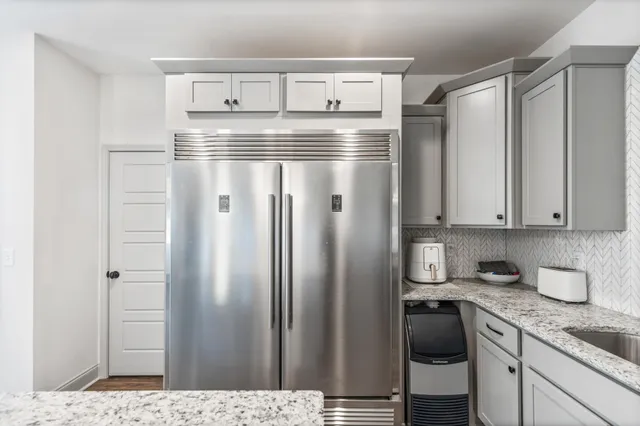 a kitchen with stainless steel appliances granite countertop a refrigerator and a stove