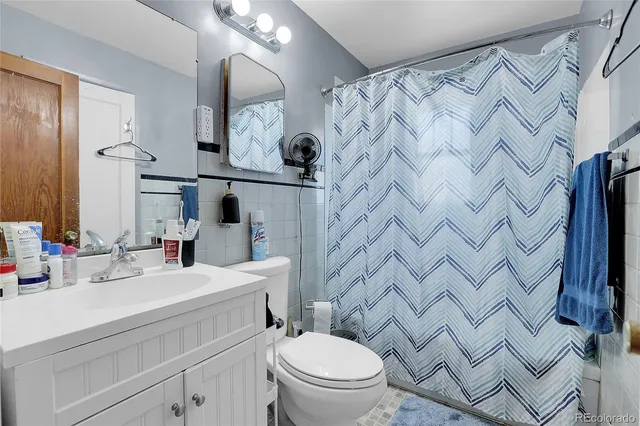 a bathroom with a sink vanity mirror and toilet