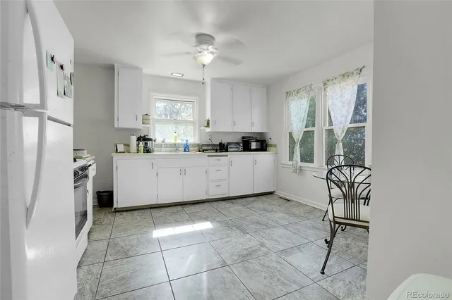 a kitchen with a sink a refrigerator and cabinets