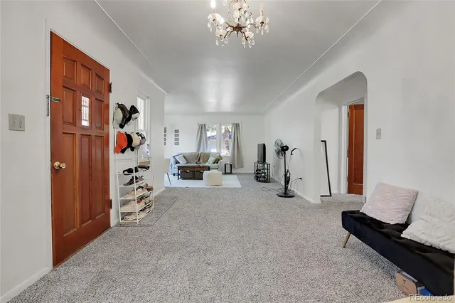 a living room with furniture gym equipment and a chandelier