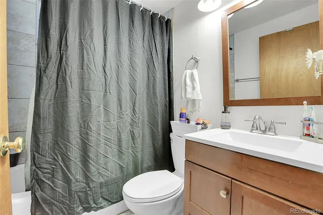 a bathroom with a sink a toilet and shower curtain