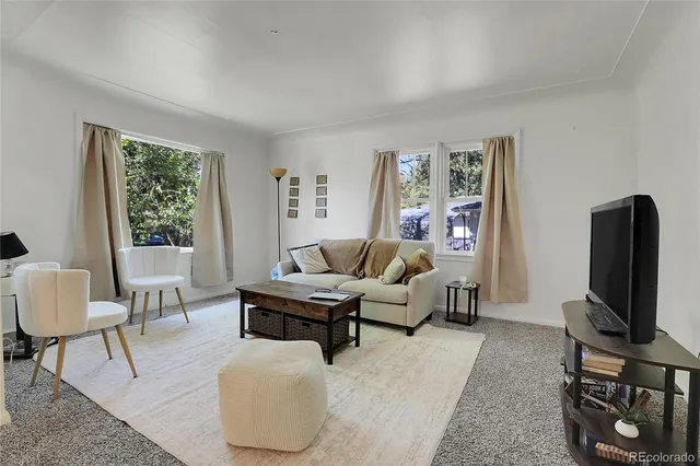 a living room with furniture a window and a flat screen tv