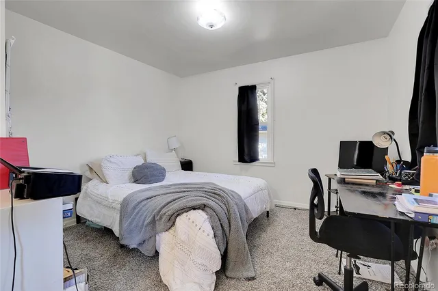 a bedroom with bed and a desk