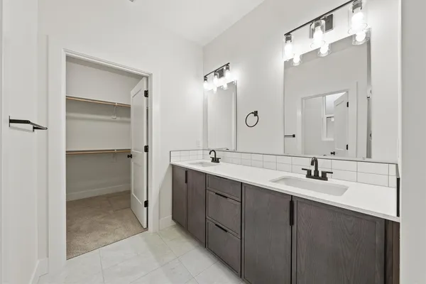 a bathroom with a double vanity sink and mirror