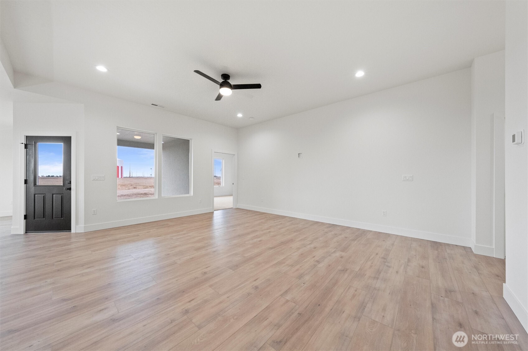 1269 E Mount Othello, WA 99344 - Photo 3 of 32 a view of an empty room with wooden floor and a ceiling fan