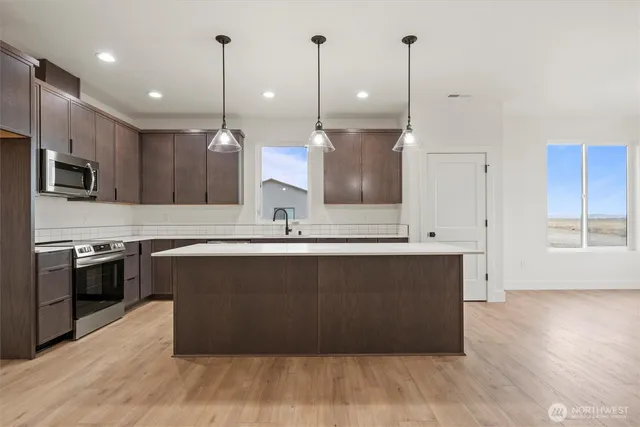 a kitchen with kitchen island a sink and a stove