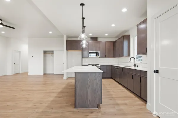 a large kitchen with kitchen island a sink stainless steel appliances and a center island