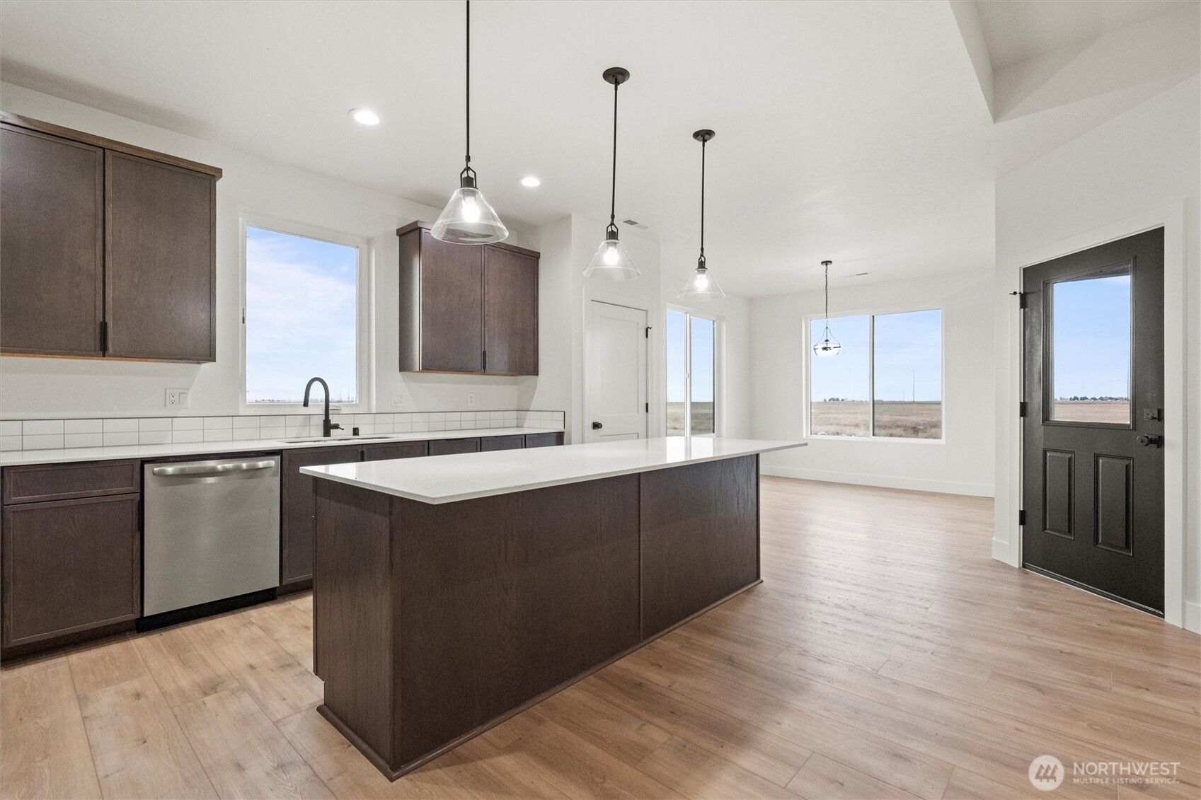 1269 E Mount Othello, WA 99344 - Photo 7 of 32 a large kitchen with stainless steel appliances kitchen island granite countertop a sink stove and wooden floor