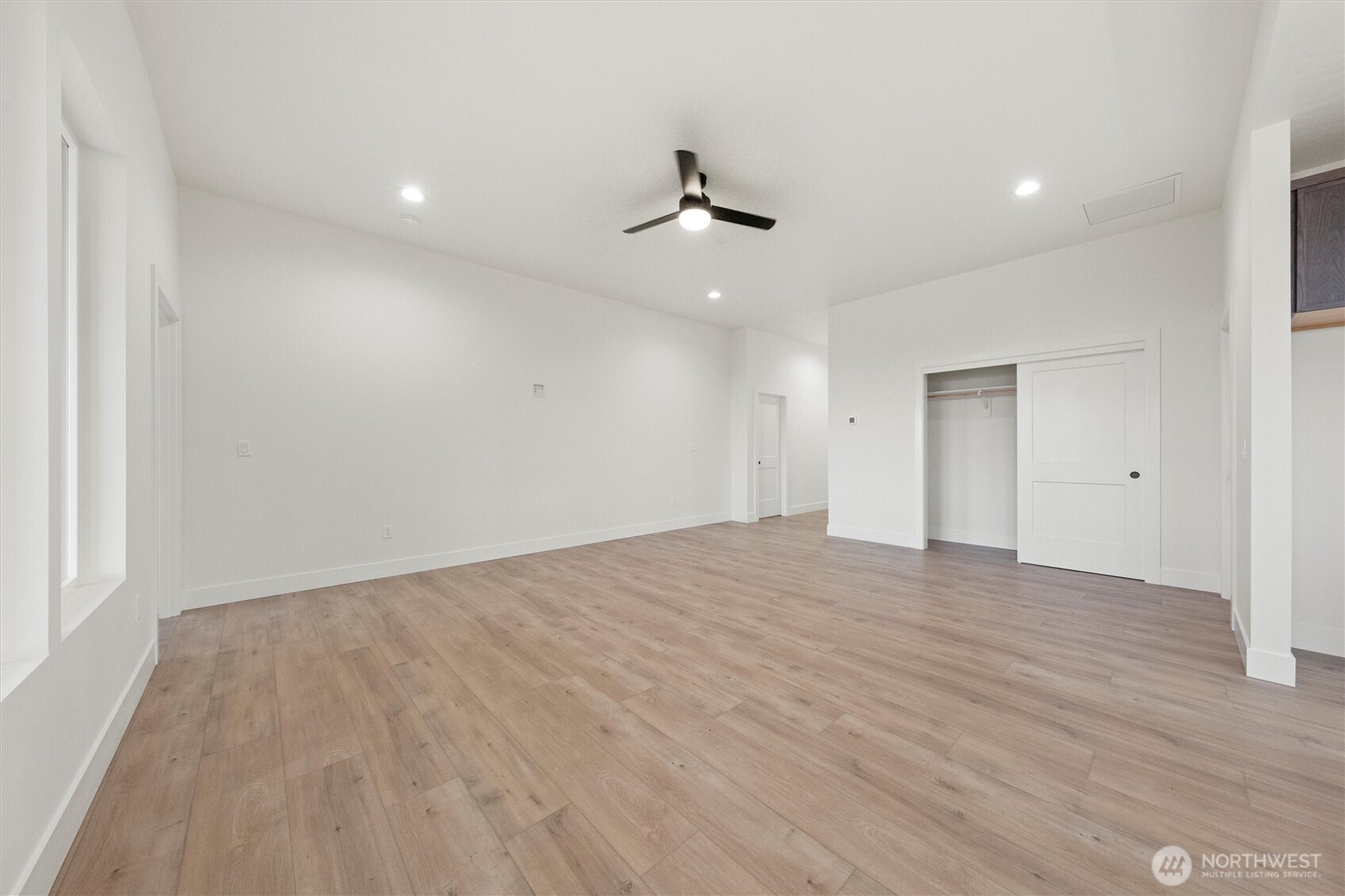 1269 E Mount Othello, WA 99344 - Photo 8 of 32 an empty room with wooden floor ceiling fan and windows